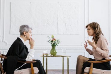 Executive Coaching Session: Führungskraft im professionellen Hypnose-Beratungsgespräch in elegantem Büroambiente